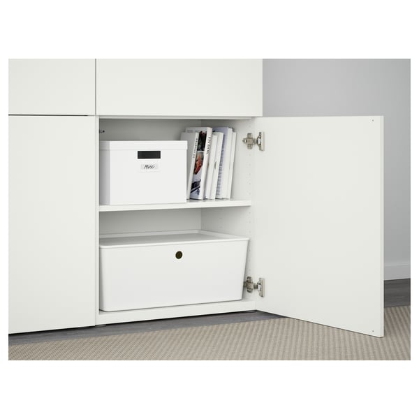 White BESTÅ cabinet with adjustable shelves and soft-close doors, showing organised storage including a white box and magazines.
