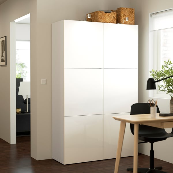 White BESTÅ cabinet, large and tall, in modern home office. Tall, sleek storage with clean lines, positioned next to desk.