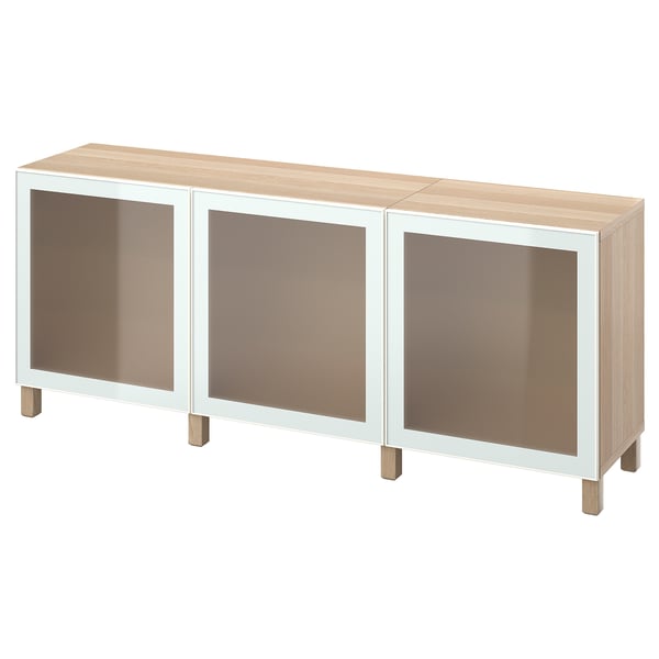 An ikea BESTÅ sideboard in light oak and white. It three glass doors and wooden legs.