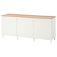 This image shows a white BESTÅ sideboard with wooden top and legs. It has three sections with vertical grooves and no visible handles.