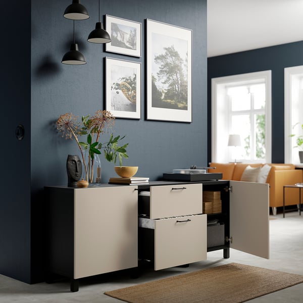 Modern sideboard with adjustable shelves, drawers, and door storage against dark wall, featuring decorative objects and artwork.