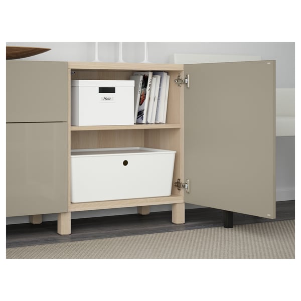 Open cabinet with books and boxes on shelf. Drawers below, adjustable hinges visible.