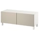 An ikea BESTÅ tv bench in white with beige doors, featuring two cabinets and adjustable shelves for storage.