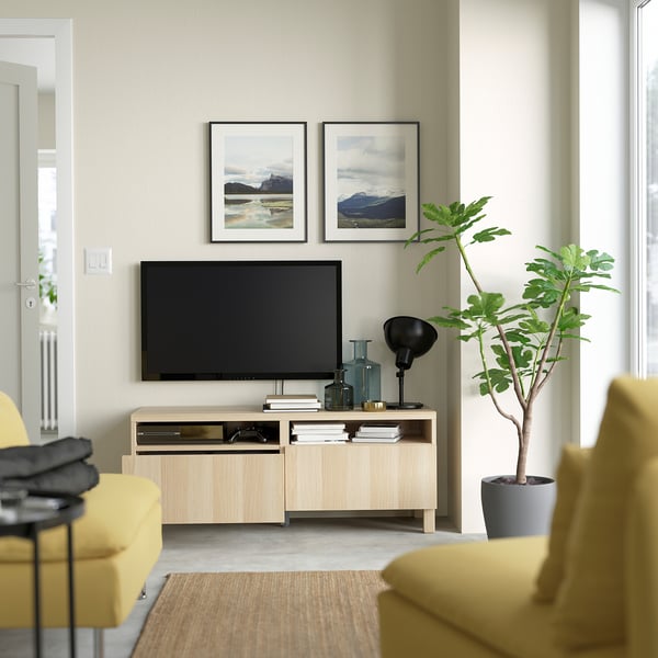 Modern living room with BESTÅ tv bench, yellow armchairs, and storage.