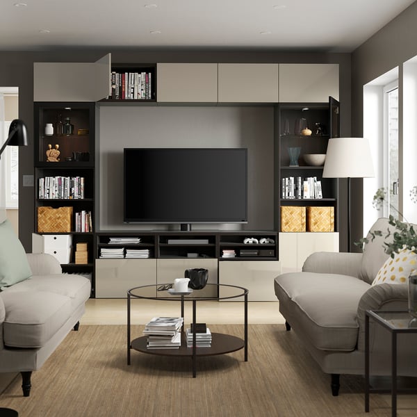Modern living room with BESTÅ tv unit, adjustable shelves, and large windows. Two sofas and a glass coffee table.