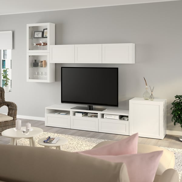 Modern BESTÅ tv setup with storage, coffee table, and wicker chair in clean living room.