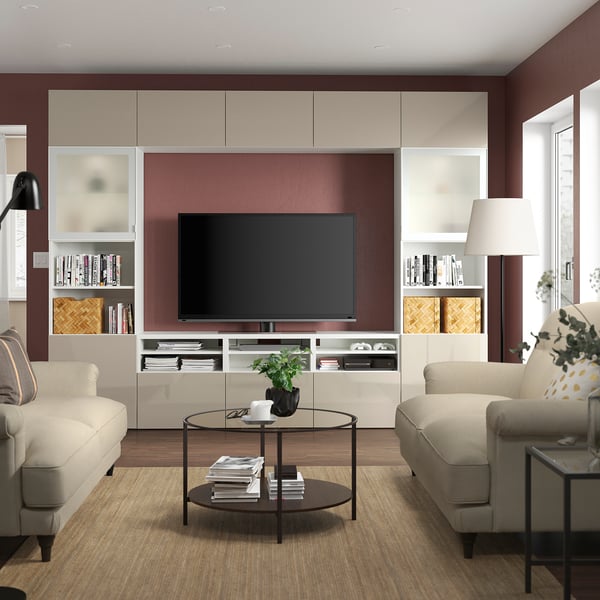 Modern living room with BESTÅ tv unit, tv, bookshelves, beige couches & coffee table.