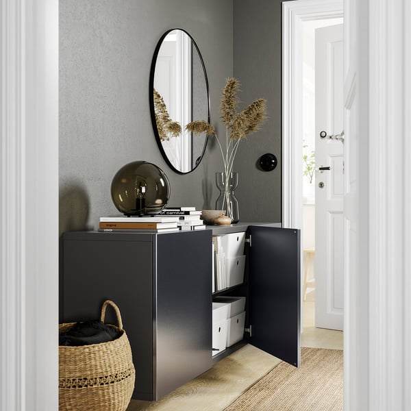 Modern entryway with BESTÅ storage in black, organised with boxes, shelves, lamp, mirror.