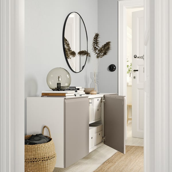 BESTÅ wall cabinet with mirror, bulb, vase, and basket.