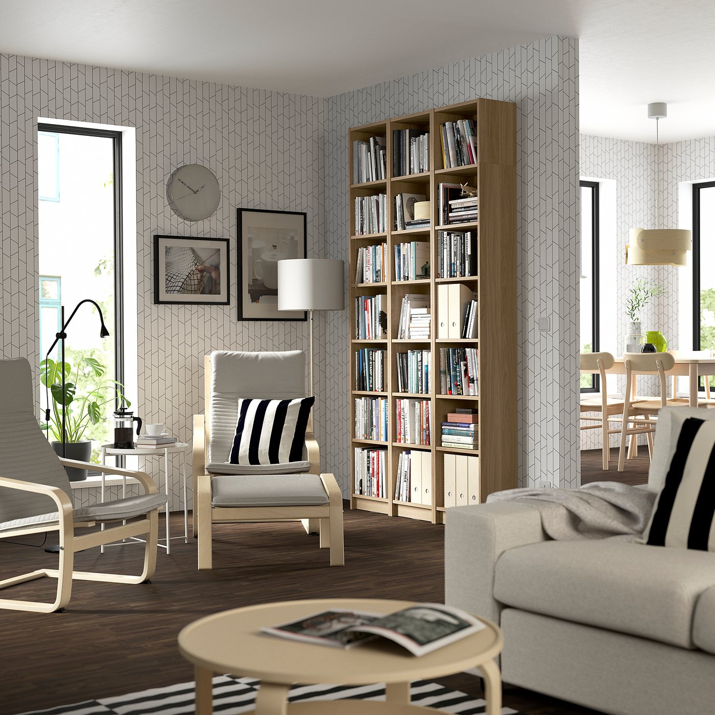Modern living room with BILLY bookcase, light wood, adjustable shelves, large, next to grey sofa and striped chairs.