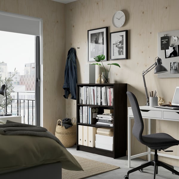 Modern home office with BILLY bookcase, laptop desk, and city view.