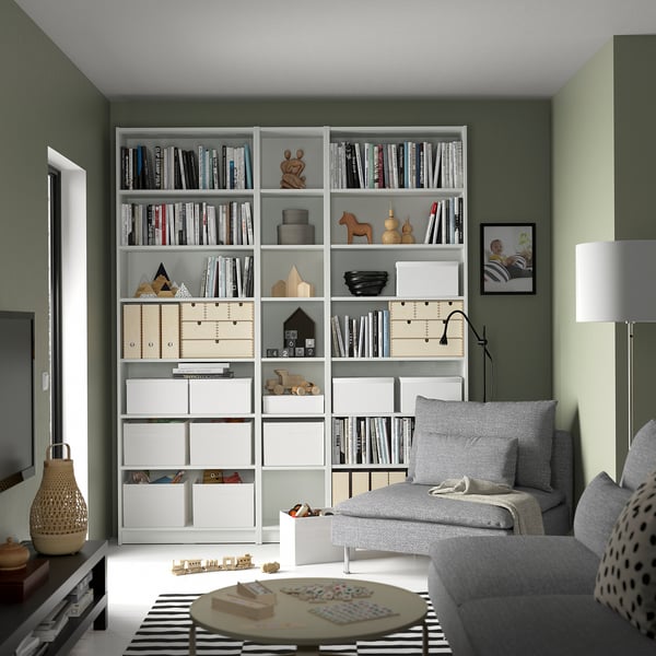 Grey BILLY bookcase with items, sofa, and puzzle table.