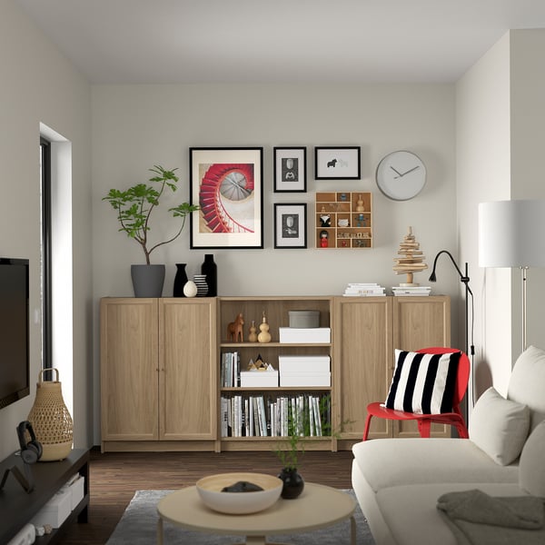 Living room with BILLY bookcase, sofa, coffee table, art gallery, lamp, and plant.