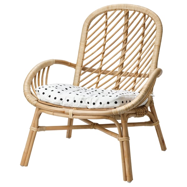 Bamboo chair with white polka dot cushion. Natural colour. Round shape and intricate weave. Comfortable with armrests and legs.
