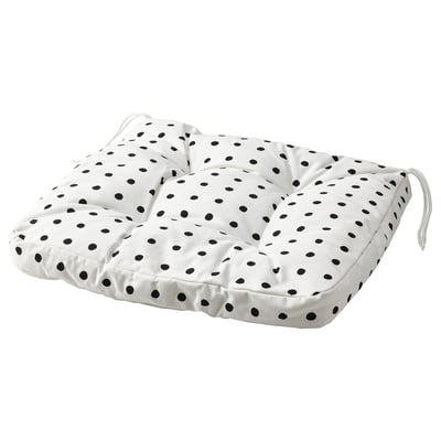 A BJÖRKTRAST cushion with black polka dots on a white background. It is square-shaped with ties on each corner for secure placement.