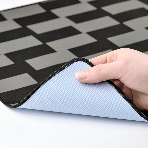 Gaming mouse pad with textured rubber bottom and grey-black chequered top.
