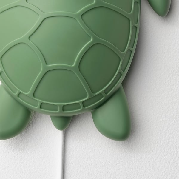 Green turtle-shaped wall lamp; detailed shell pattern; soft light, perfect for childs room.
