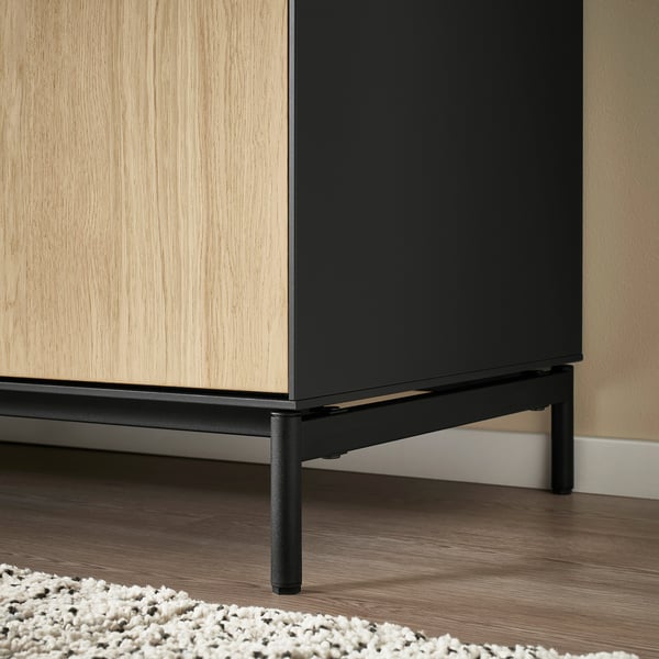 Modern sideboard with sleek lines. Wooden doors and black metal legs. Stands on adjustable feet for stability.