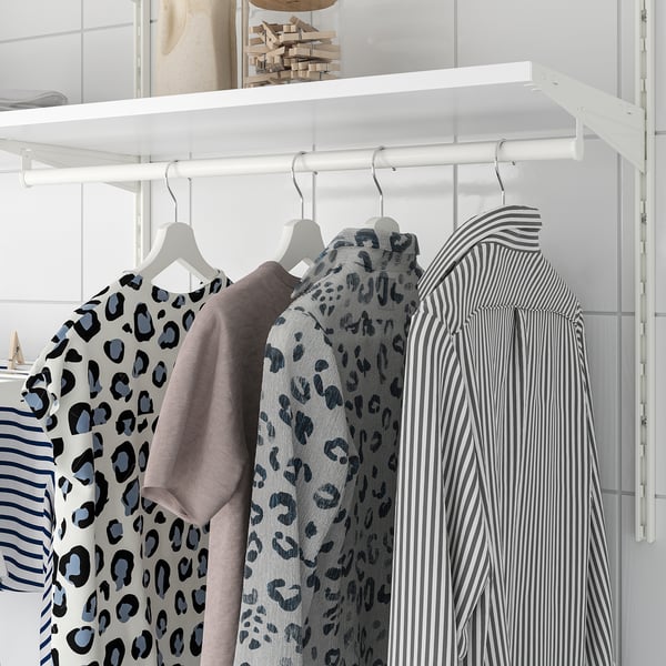 Closet with hanging shirts: leopard-print, solid grey, striped. White rail, shelves, hooks.