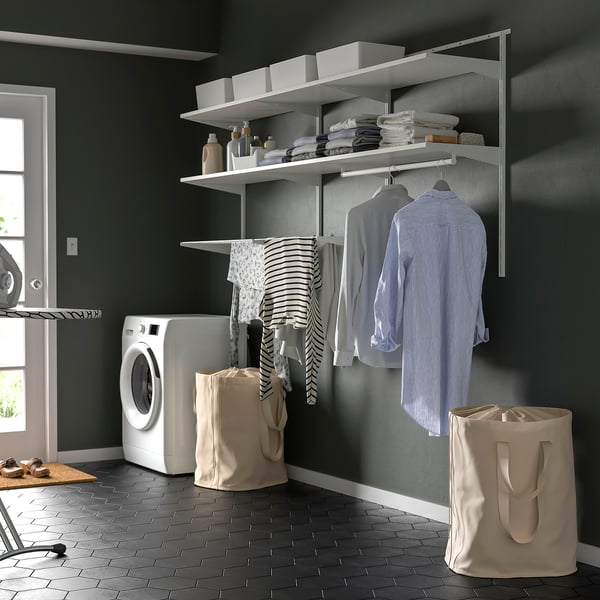 BOAXEL wall storage in laundry room with drying rack, clothes, and bags.
