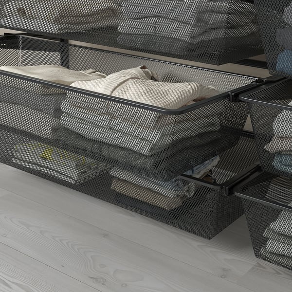 Mesh storage baskets on metal frame, ideal for folded clothes, mounted on wall.