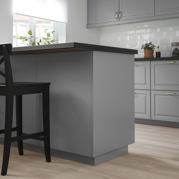 Modern grey kitchen island with black stools, large countertop, sleek cabinets, clean design.