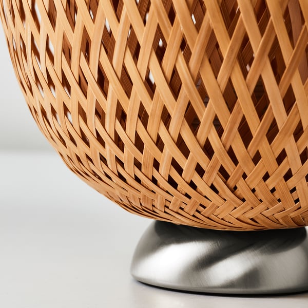 Intricate bamboo lamp shade on sleek metal base.