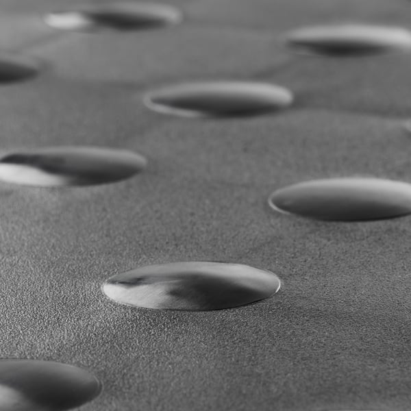 Close-up of textured black steps, smooth and robust, arranged in a repetitive pattern.