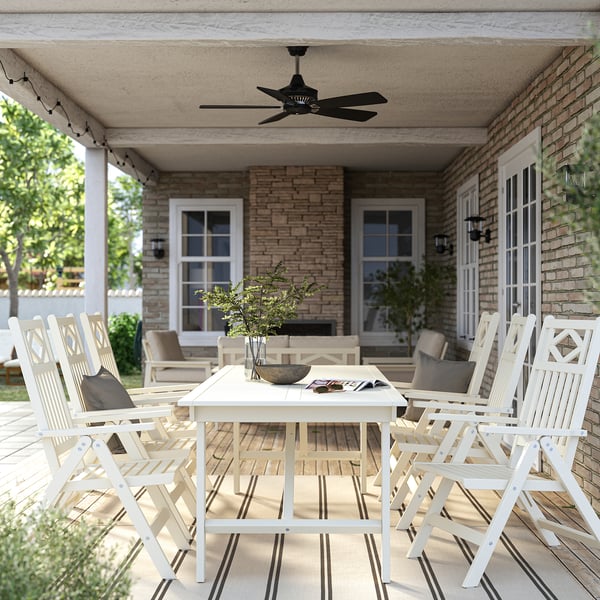 Outdoor dining set with table, 8 folding chairs, ceiling fan, green background