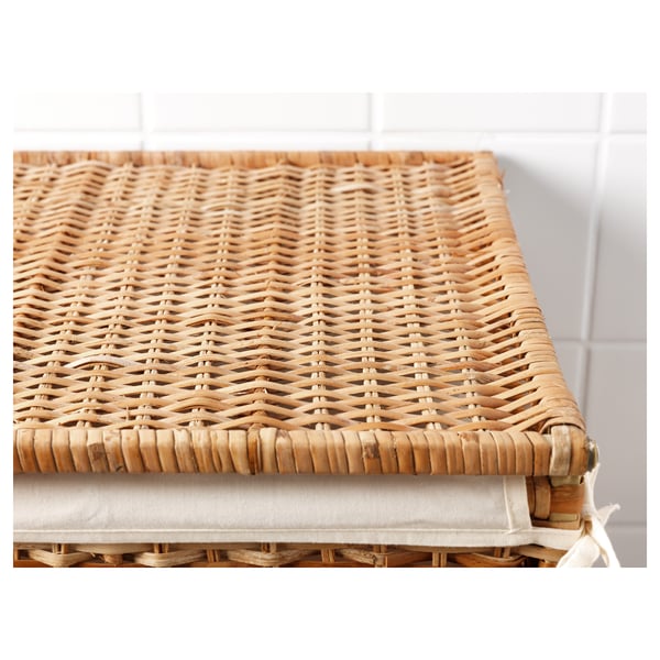 A wicker laundry basket with intricately woven rattan, showcasing high-quality craftsmanship. It a sturdy base and a removable liner.