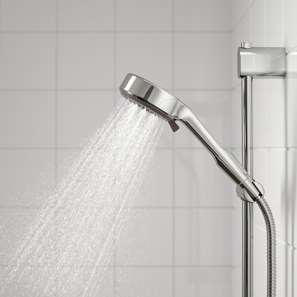 Chrome shower head with full spray in action, even water flow, adjustable height.