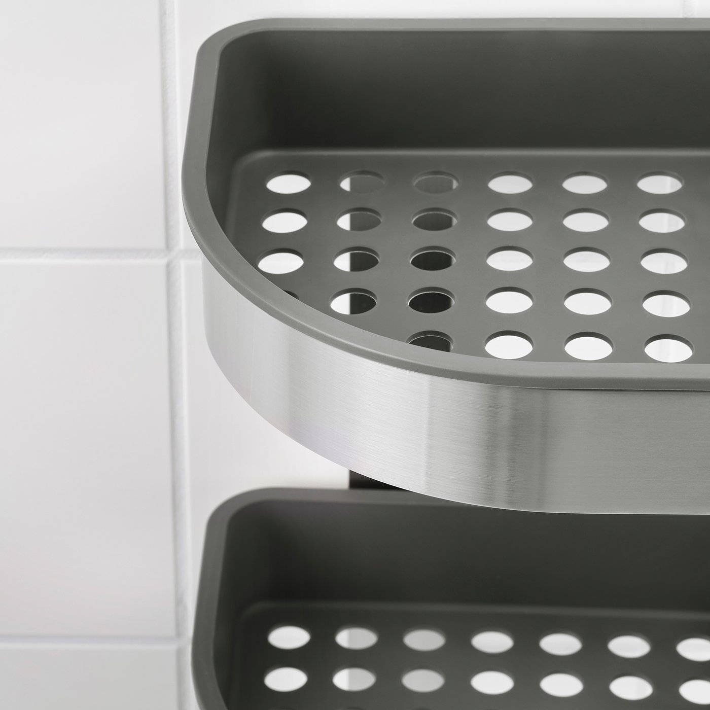 Modern stainless steel and plastic bathroom storage shelf, with perforated design for drainage.