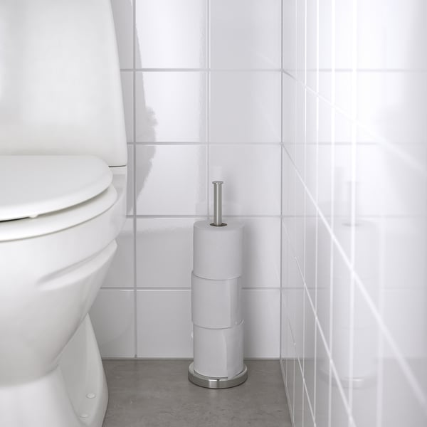 BROGRUND holder with 3 rolls near white toilet. Alternative: BROGRUND toilet paper holder with 3 rolls by white toilet.