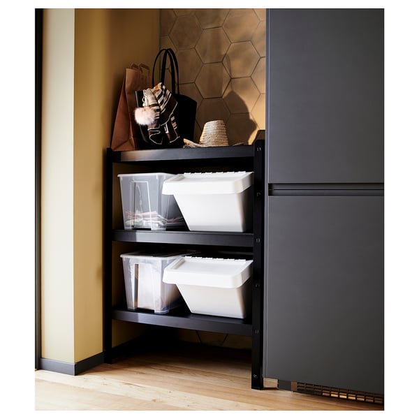 Black metal storage shelf with hexagonal wall pattern, plastic bins, and accessories.