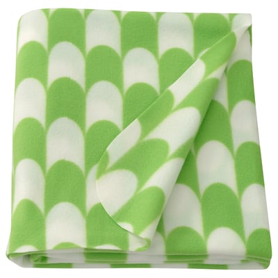 Folded lime green & white patterned throw blanket, scalloped design, soft polyester.