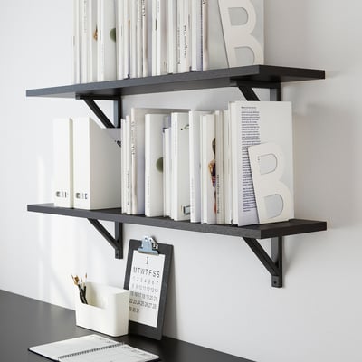 Black wall shelves with books and decorative items. Includes a clipboard with pencils.