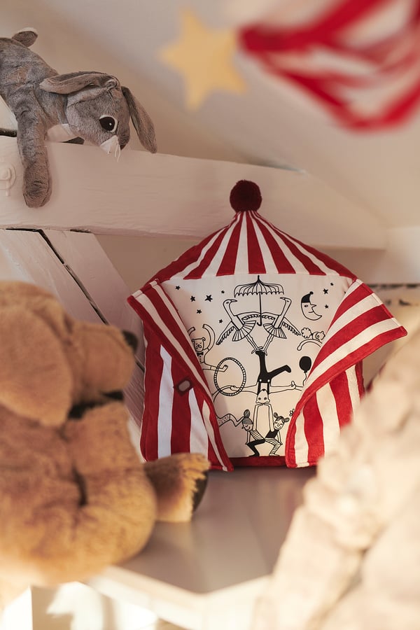 Childs room with circus tent cushion & stuffed animals.