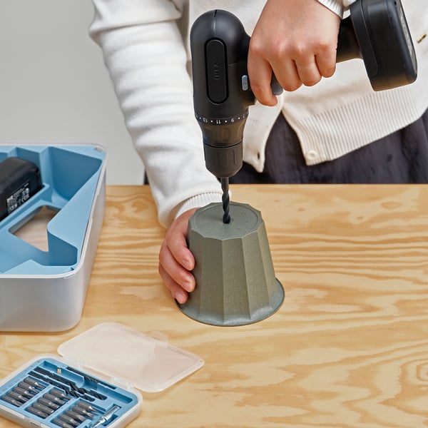 Drilling potted plant with power tool.