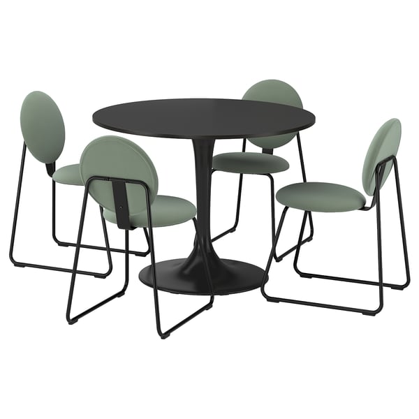 Black round dining table with four green cushioned chairs, sleek metal legs, modern design.