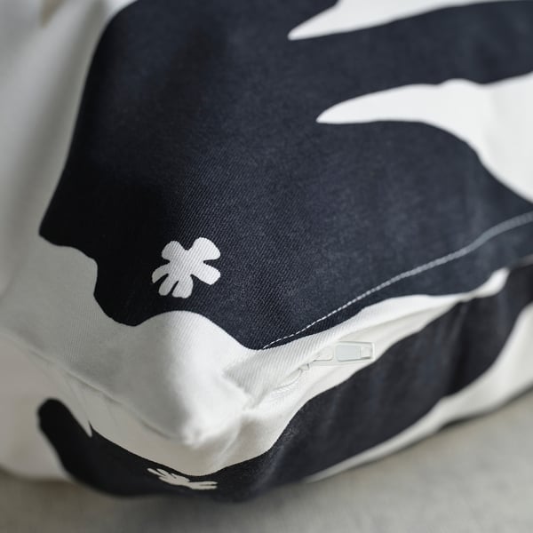 Black and white patterned cushion cover with floral design, made of soft, recycled cotton, featuring a zip.