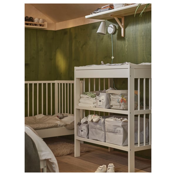 Nursery with DRÖMSLOTT changing table, shelves, and green walls.