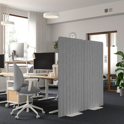 Office with EILIF screens for noise reduction and privacy, desks with computers and ergonomic chairs.