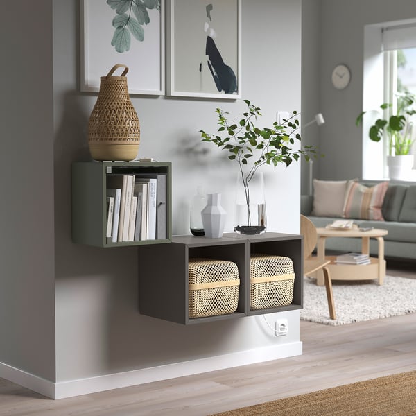 Modern living room with wall-mounted green EKETs, books, vases, and plants.