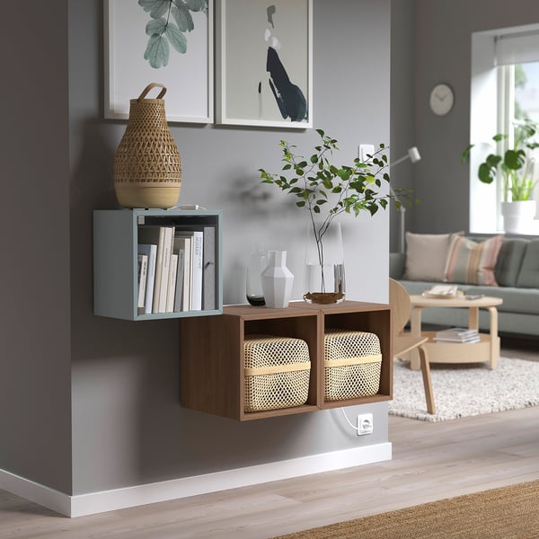 EKET grey-blue bookcase with glass and wood, holding books and decor. Smaller than the sofa and larger than vases.