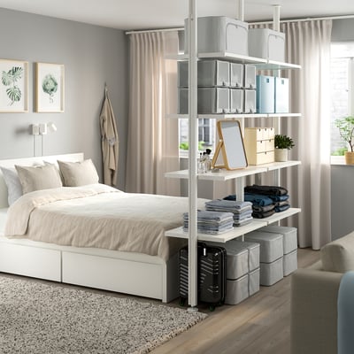 Modern bedroom with ELVARLI storage, tall bed, large windows, and green plants.