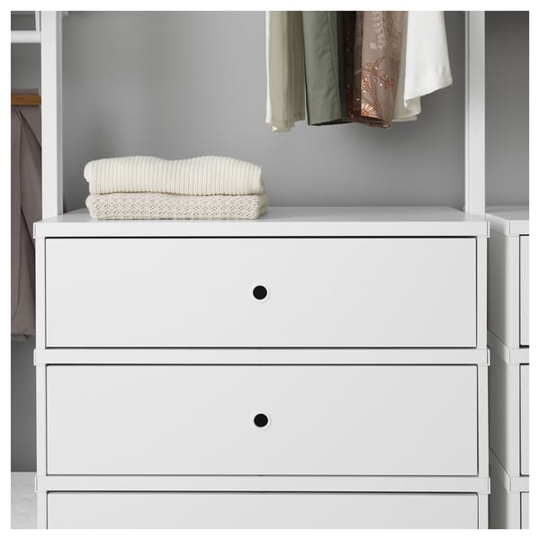 A white wardrobe with drawers and folded blankets on top, showing room organisation.