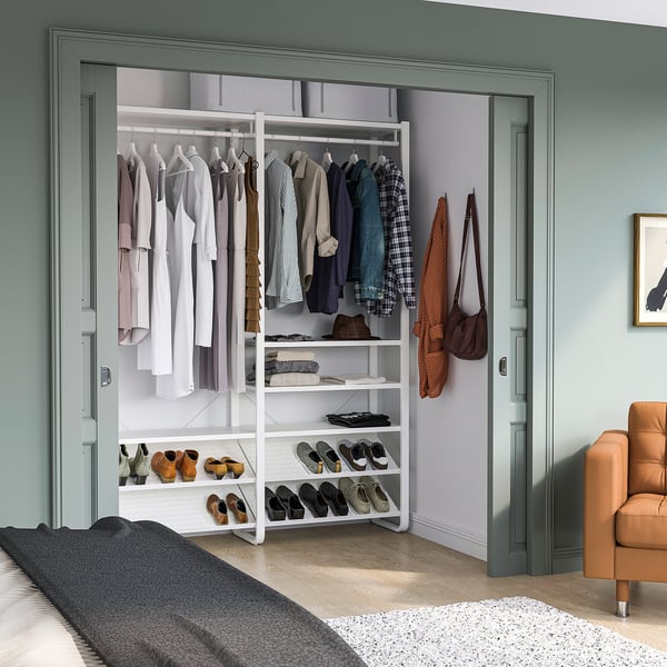 ELVARLI wardrobe in bedroom with shelves, hanging section, and orange chair.