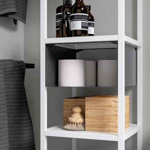 White ENHET shelf insert divides space on a wall shelf, holding bottles and storage boxes neatly.