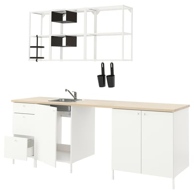 Modern white kitchen setup with light counter, integrated sink, open shelving, and accessories.