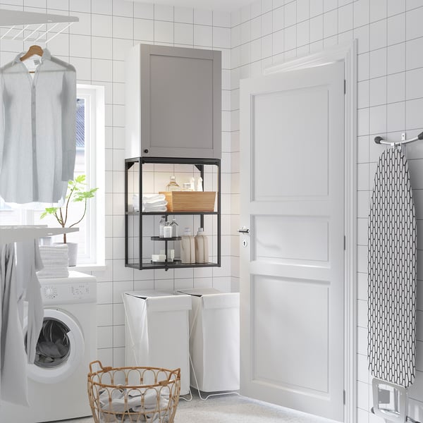 Modern laundry room with grey wall cabinet, washing machine, and shower curtain.